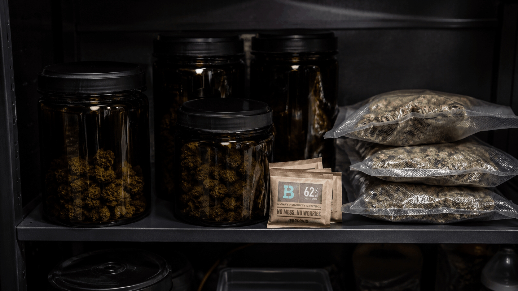 Dark amber and violet glass jars with cannabis and humidity packs stored on a cool dark shelf